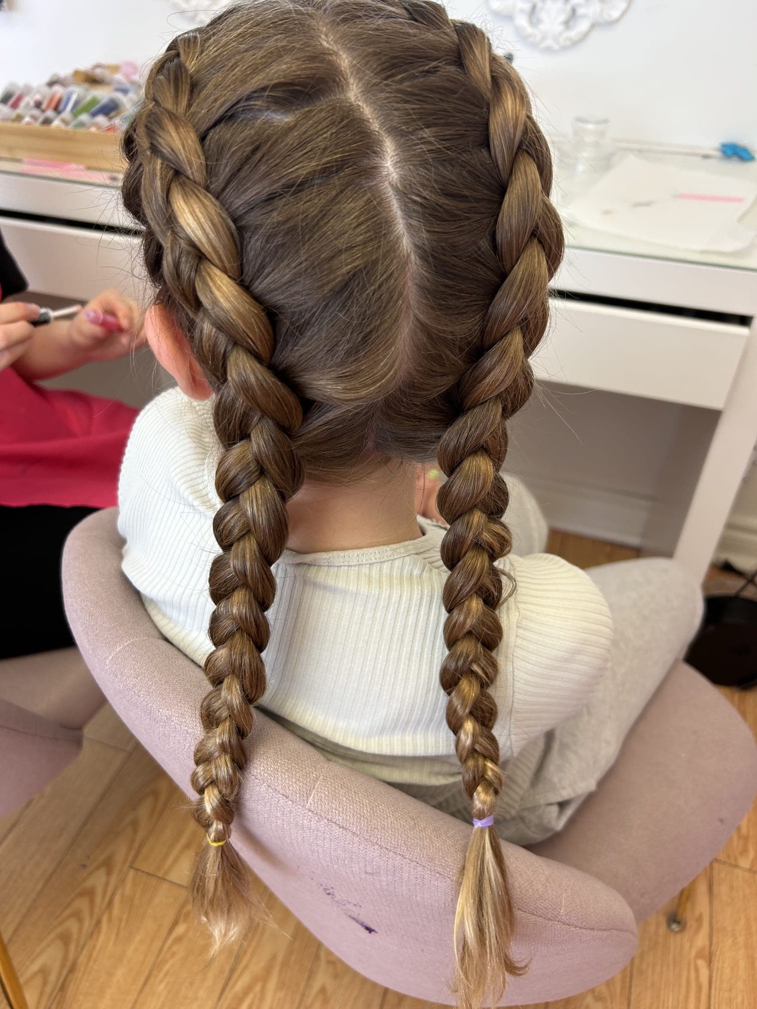 A finished double-braid hairstyle at Hily’s styling station