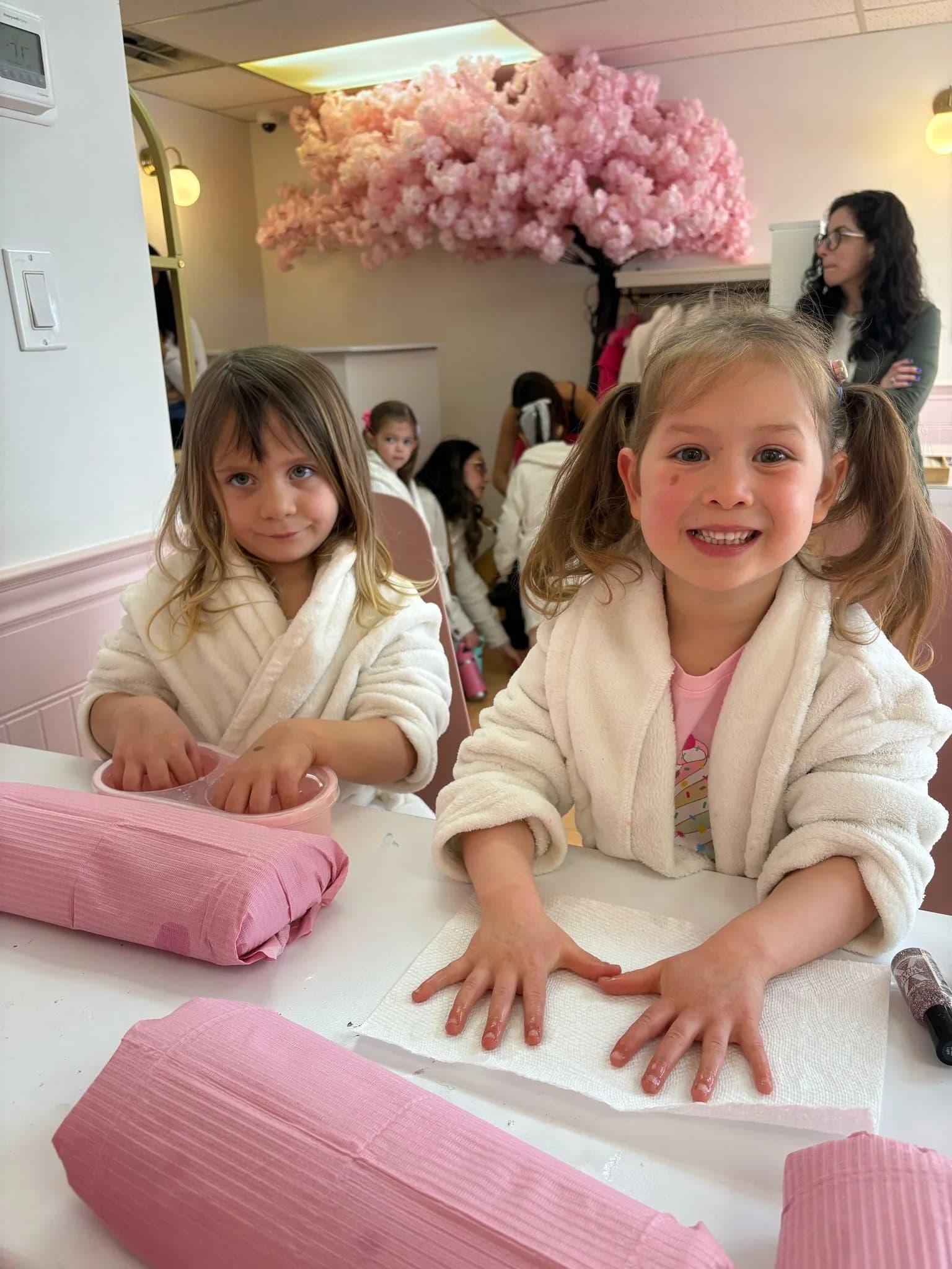 Young spa guests in robes enjoying their manicure time