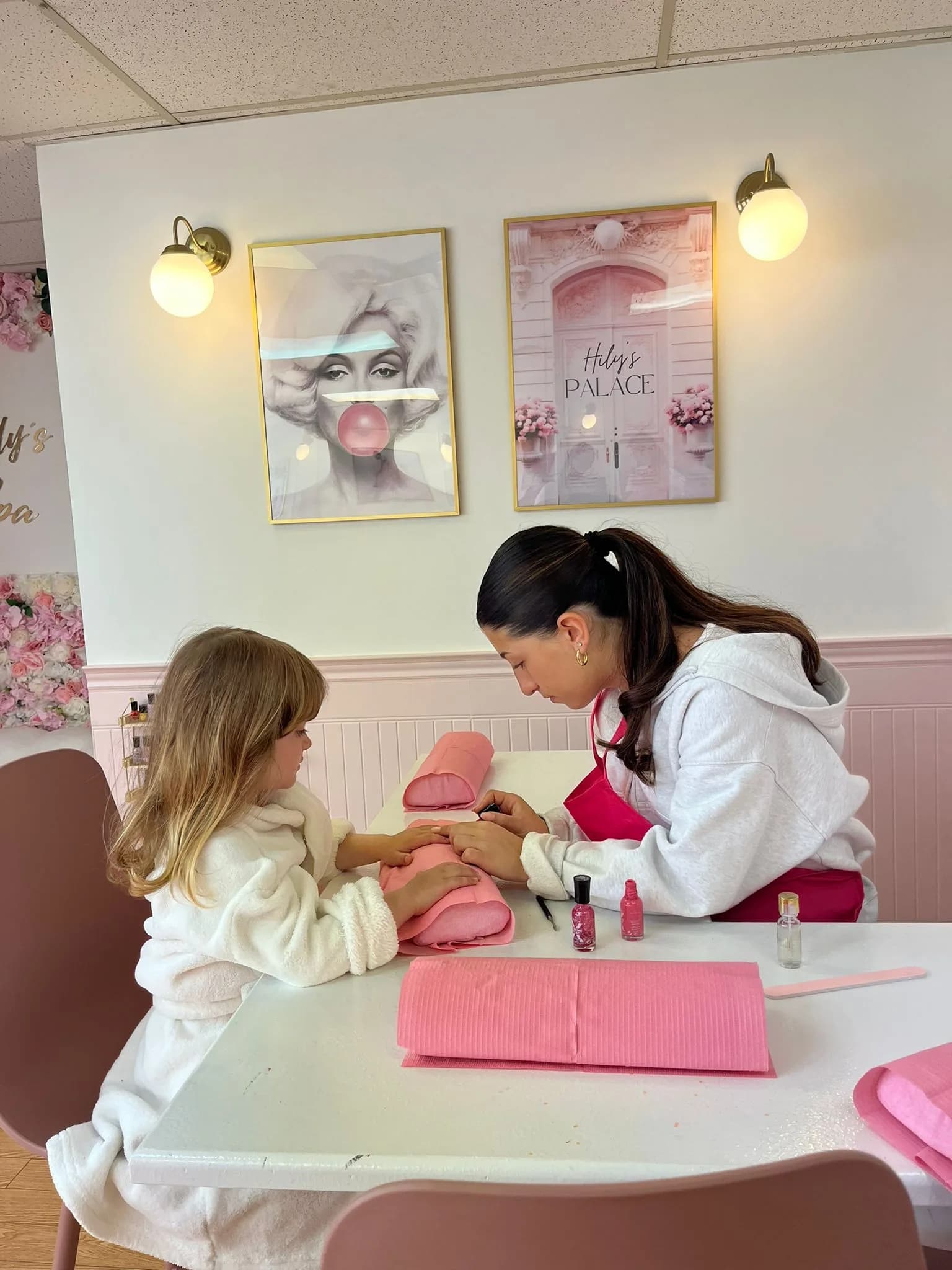 A Hily's team member giving a young guest a manicure