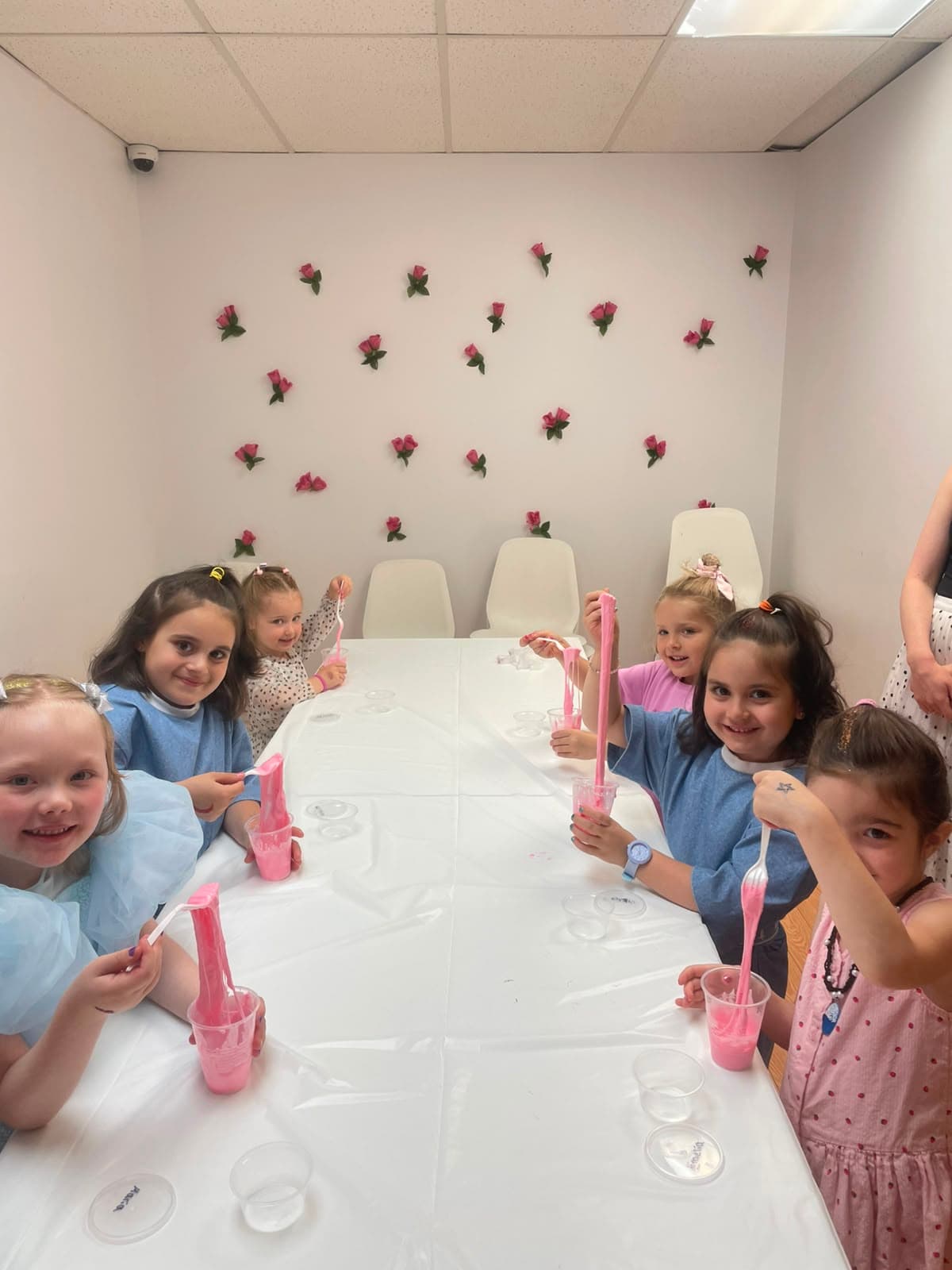 Children stretching bright pink slime at a Hily's birthday party